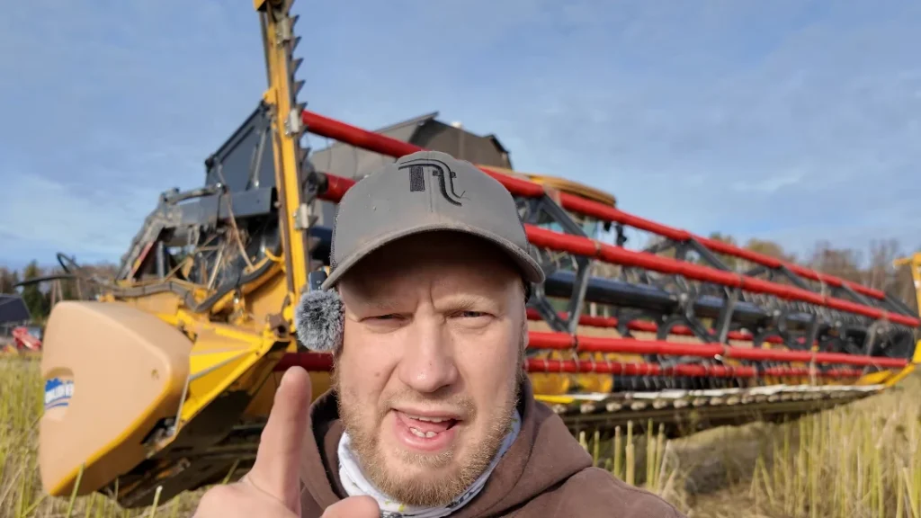 Hemp harvest: farmer in front of a combine harvester in a hemp field
