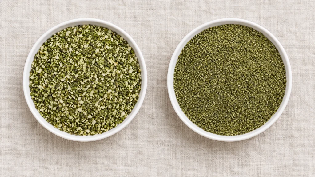 Two shallow white ceramic dishes on pale linen, left holding coarse granular green smoothie hemp and right holding finer green pressed hempseed cake meal
